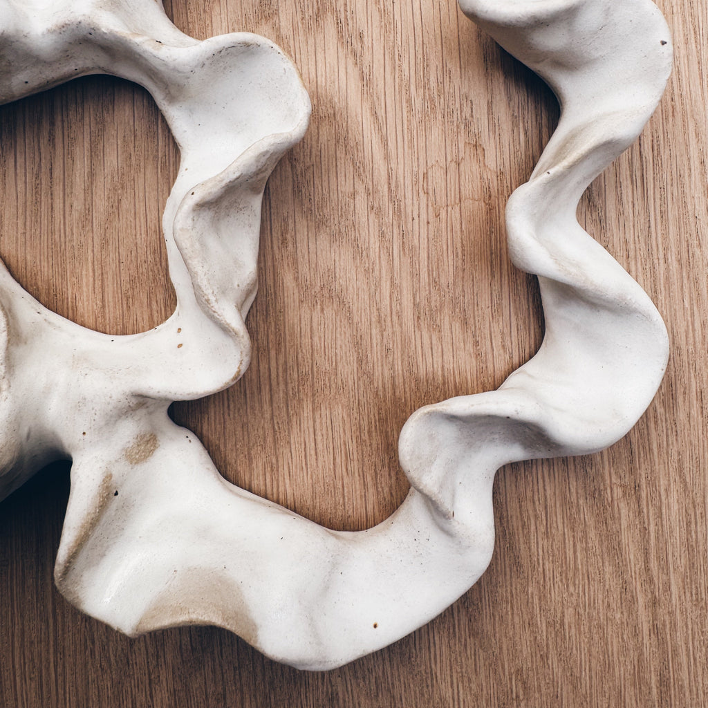 White matte coral-shaped ceramic wall decor.