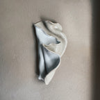 Handmade ceramic seashell wall piece with soft seafoam glaze and organic curved form