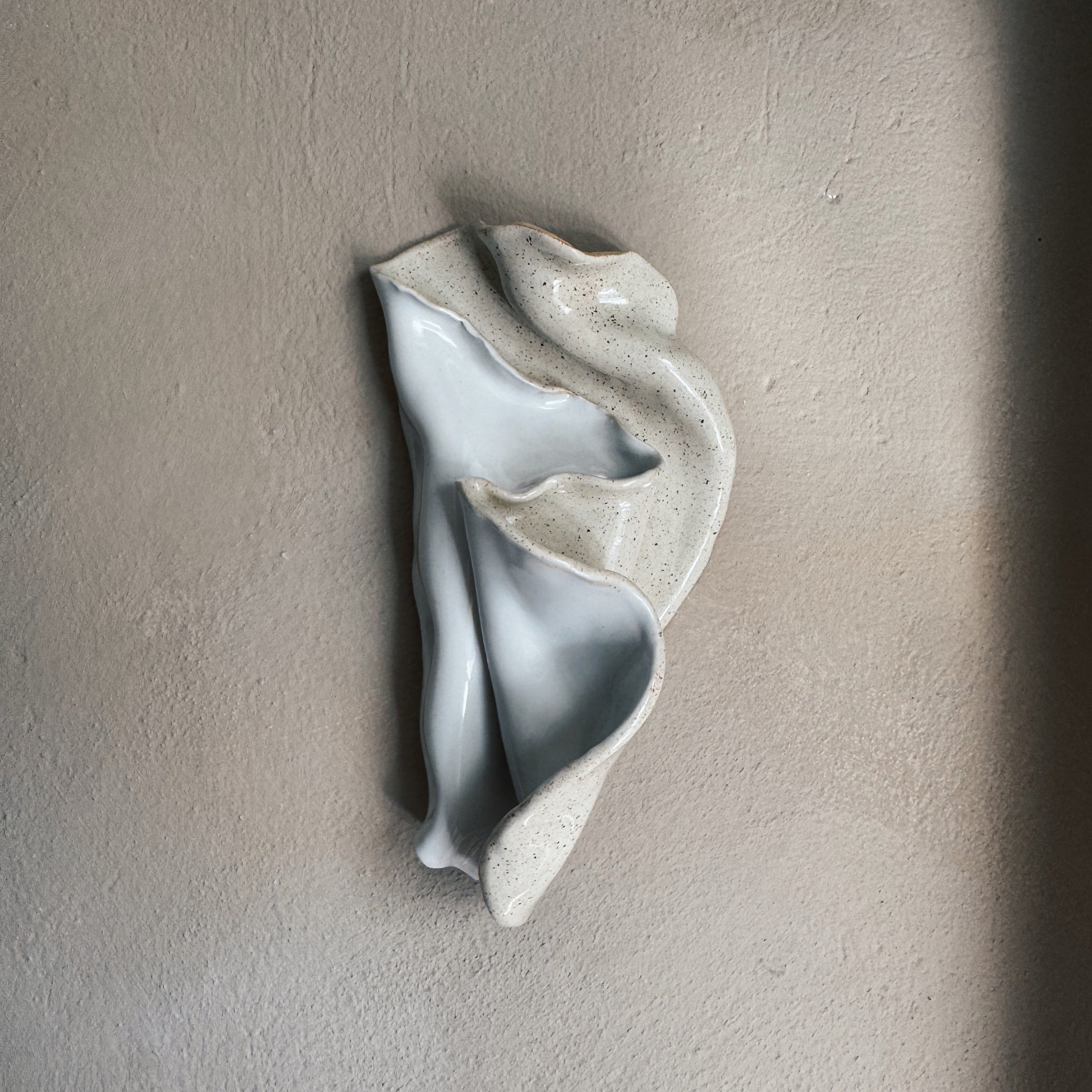 Handmade ceramic seashell wall piece with soft seafoam glaze and organic curved form